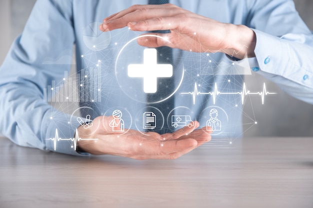 Businessman hold virtual plus medical network connection icons. Covid-19 pandemic develop people awareness and spread attention on their healthcare.Doctor,document,medicine,ambulance,patient icon.