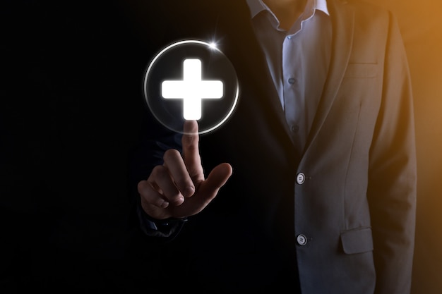 Businessman hold virtual plus medical network connection icons. Covid-19 pandemic develop people awareness and spread attention on their healthcare.