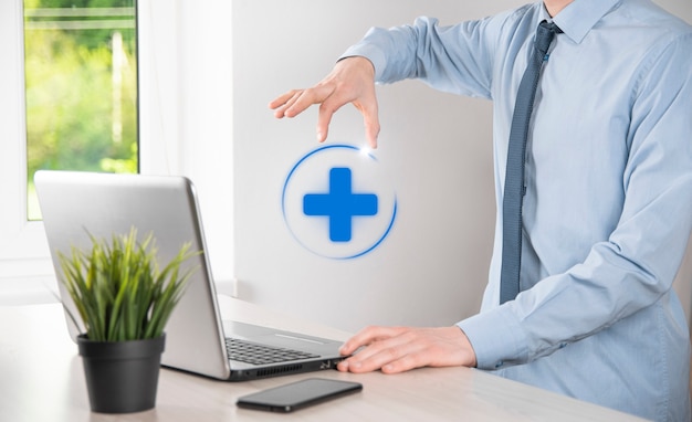 Businessman hold virtual plus medical network connection icons. Covid-19 pandemic develop people awareness and spread attention on their healthcare.