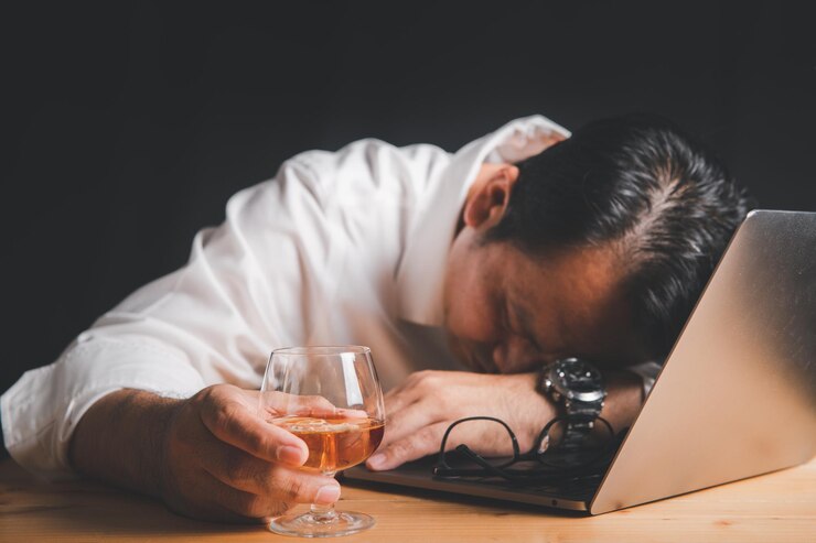 Photo businessman hold whiskey glass and sleep on laptop
