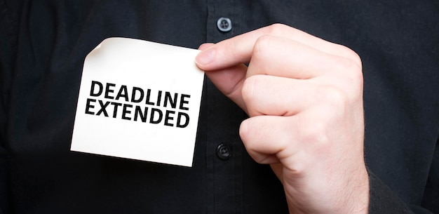 Фото Бизнесмен держит карточку с текстом deadline extended бизнес-концепции