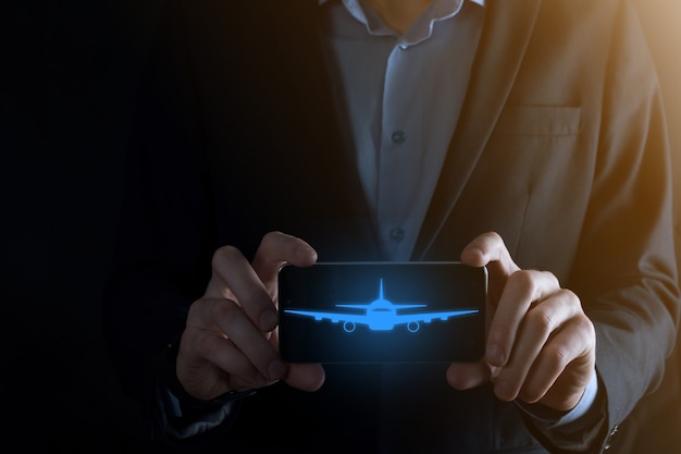 Businessman holding an airplane icon in his hands. Online ticket purchase.Travel.