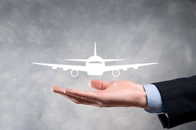 Businessman holding an airplane icon in his hands. Online ticket purchase.Travel.