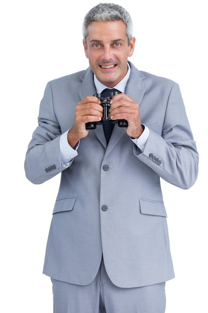 Businessman holding binoculars in both hands