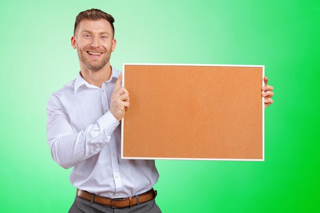 Businessman holding a blank corkboard