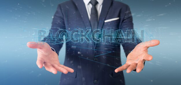 Businessman holding a Blockchain title isolated 