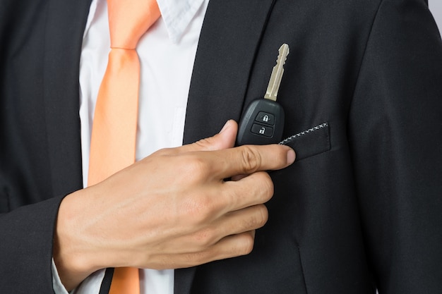 Businessman holding the  car key, isolated background