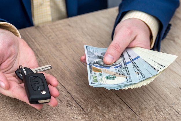 Businessman holding car key and money