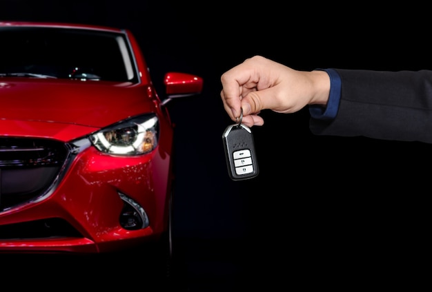 Businessman holding car keys with car background