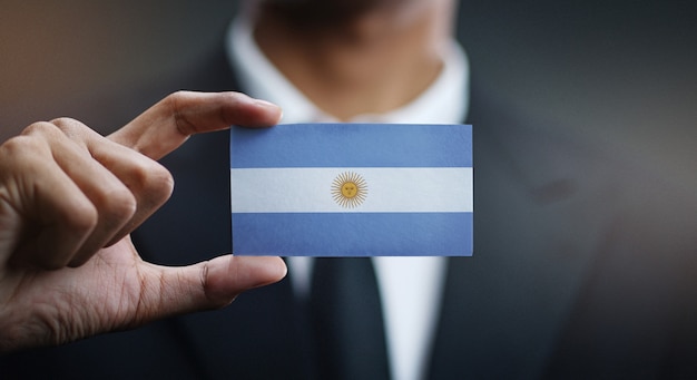 Businessman holding card of argentina flag