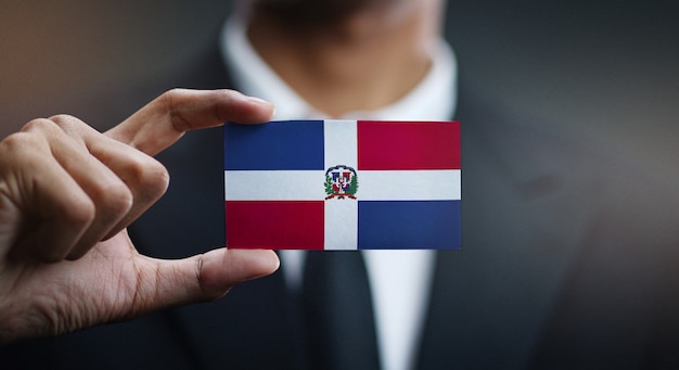 Foto uomo d'affari holding card della bandiera della repubblica dominicana