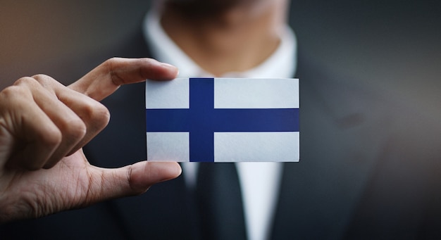 Photo businessman holding card of finland flag