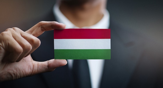 Photo businessman holding card of hungary flag