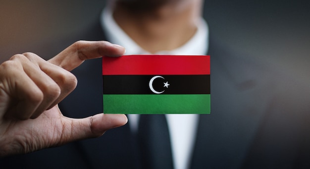 Businessman Holding Card of Libya Flag 
