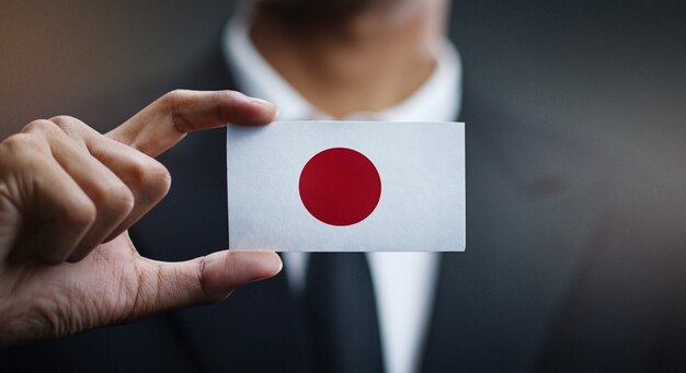Фото Бизнесмен, держа карты японии флаг