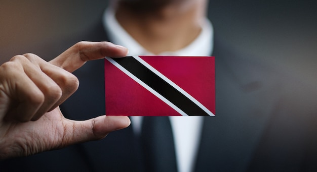 Foto uomo d'affari holding card della bandiera di trinidad e tobago