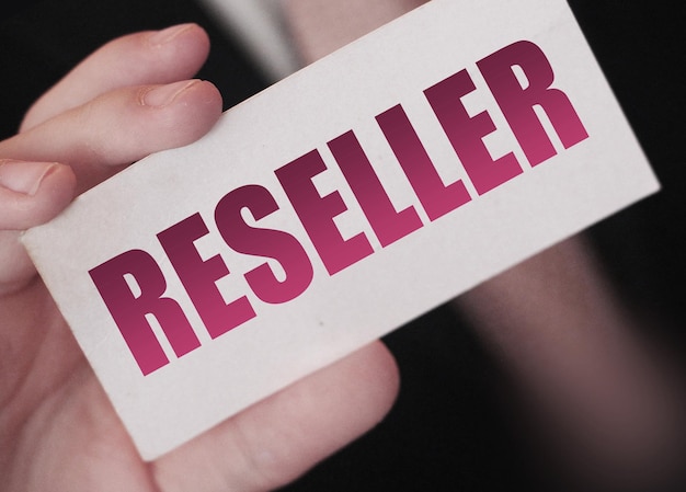 Photo businessman holding a card with reseller word reselling business concept