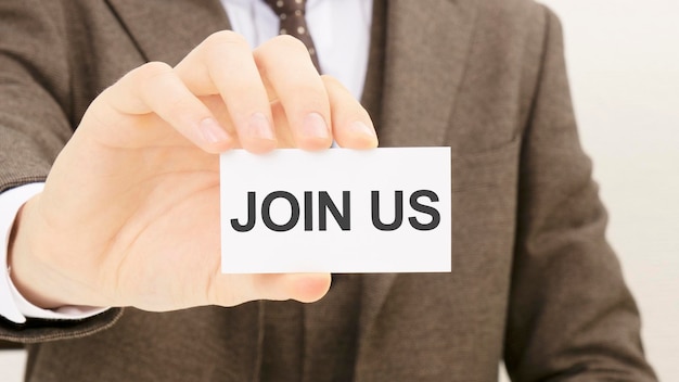 Businessman holding a card with text JOIN US