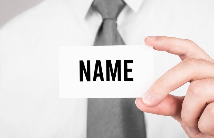 テキストNAME、ビジネスコンセプトのカードを保持しているビジネスマン