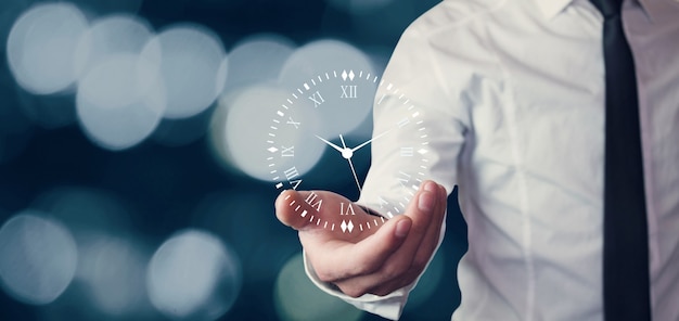 Photo businessman holding clock symbol on blurred background