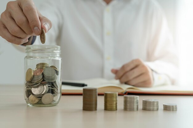 Businessman holding a coin in a piggy bank Money saving financial accounting income and investment concept