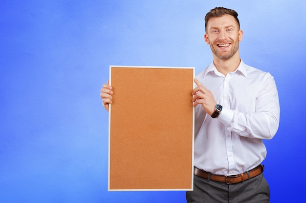 Businessman holding a corkboard 