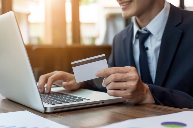 businessman holding credit card and using laptop computer. Online shopping concept