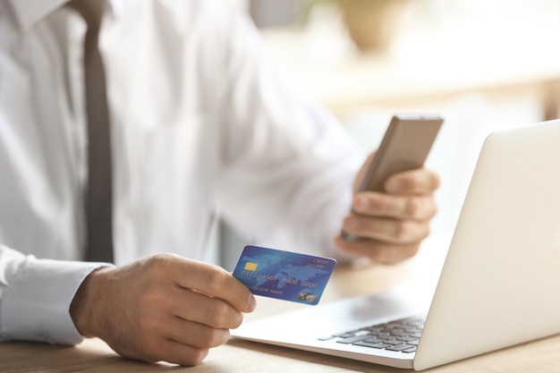 Businessman holding credit card while making call