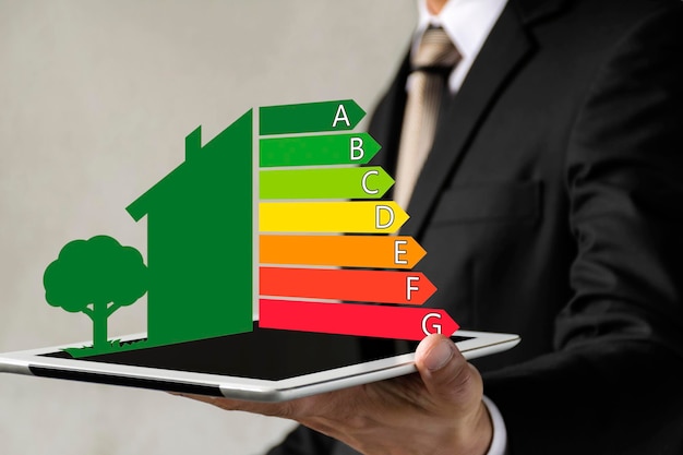 Imprenditore in possesso di tablet digitale e guardando la valutazione di efficienza della casa dettaglio della valutazione di efficienza della casa sullo schermo della tavoletta digitale concetto di casa ecologica e bioenergetica classe energetica