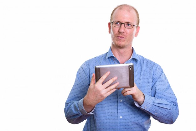 бизнесмен держит цифровой планшет, думая и глядя вверх