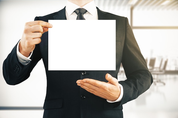 Businessman holding empty paper sheet