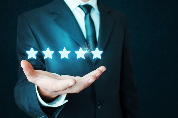 Businessman holding five stars concept