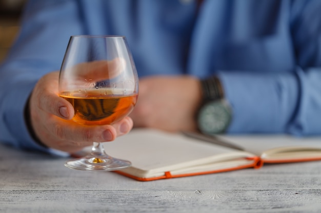 Businessman holding a glass of whisky, close up