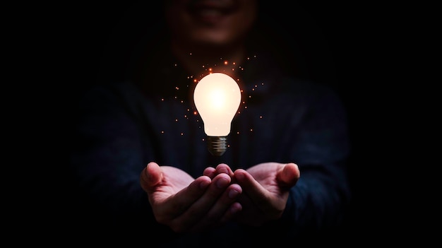 Businessman holding glowing lightbulb for creative thinking and problem solving concept.