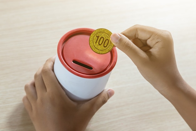 Businessman holding gold coins putting in coin bank. concept saving money for finance accounting