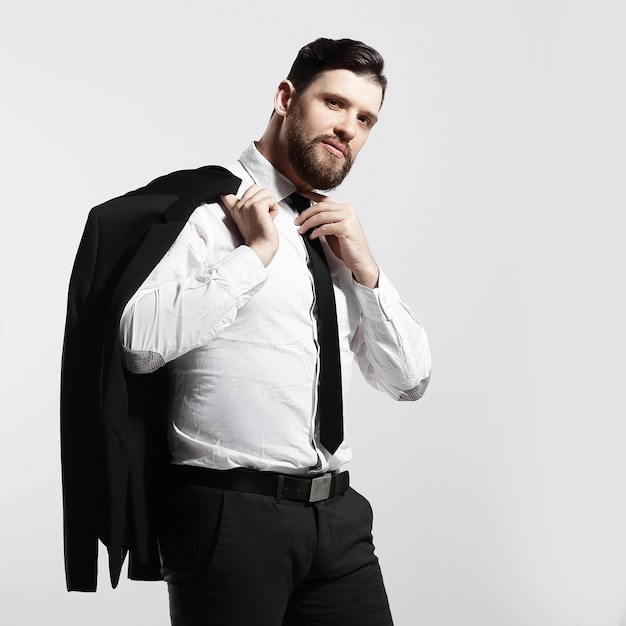 Businessman holding his jacket over his shoulder and straightens his tie