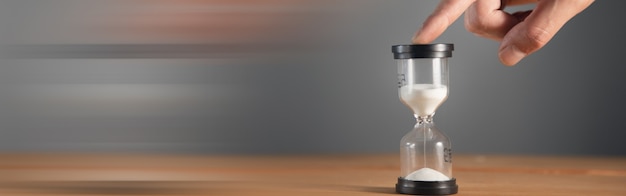 Businessman holding hourglass in the office.