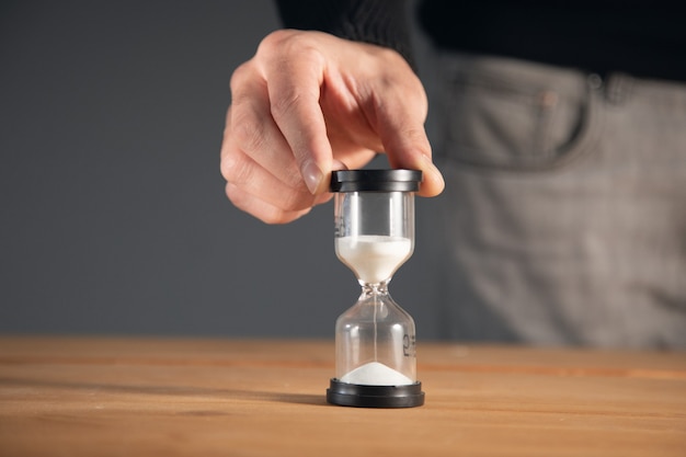 Photo businessman holding hourglass in the office.