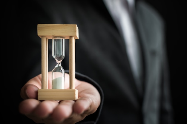 Photo businessman holding hourglass