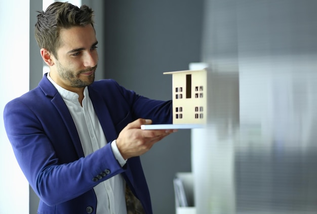 Foto miniatura della casa della holding dell'uomo d'affari a disposizione in piedi in ufficio