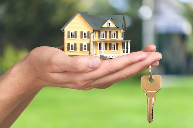 Businessman Holding House Model and Keys, Real Estate Concept