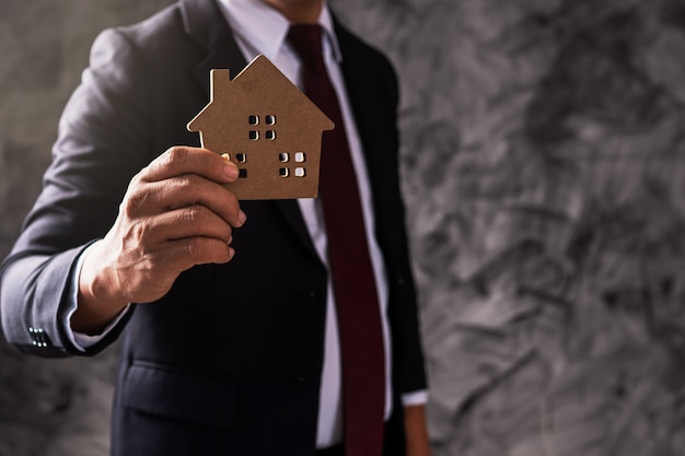 Businessman holding house model