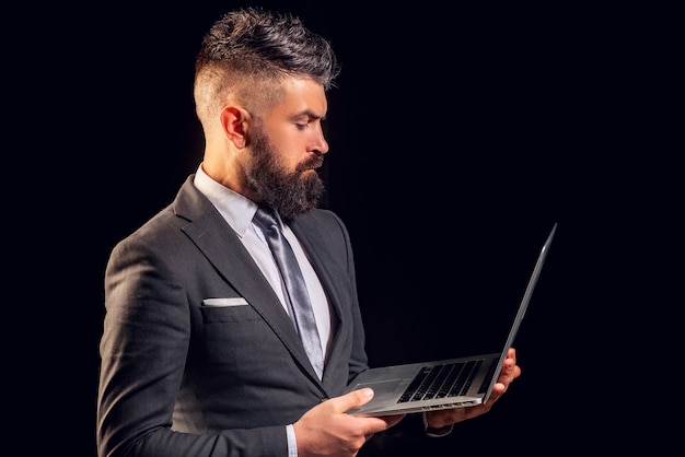 Businessman holding a laptop isolated on black