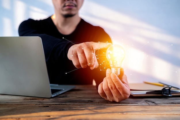 A businessman holding a light bulb in his hand demonstrates the broad vision