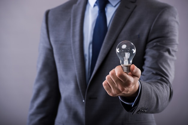 Businessman holding light bulb