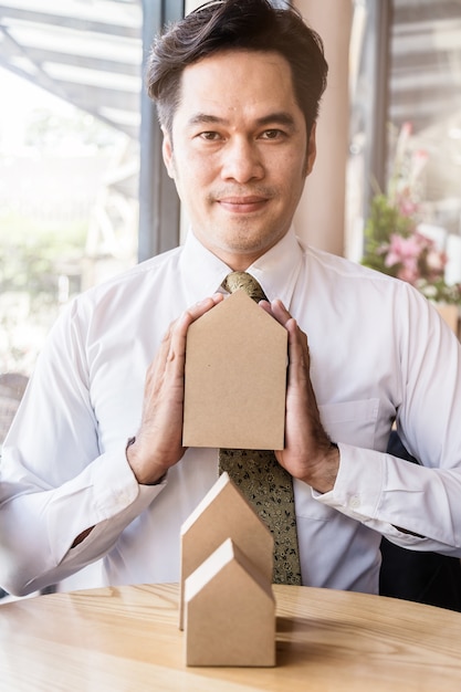 Businessman holding a little house 