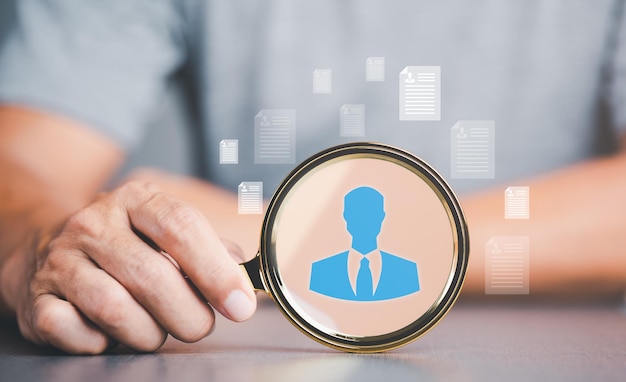 businessman holding a magnifying glass human resource recruiting concept job titles and individ