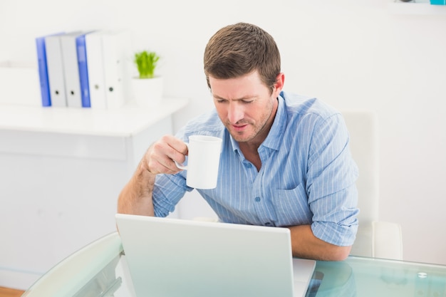 A businessman holding mug at desk