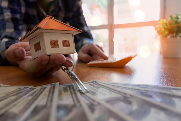 Businessman holding paper home model. Loan concept