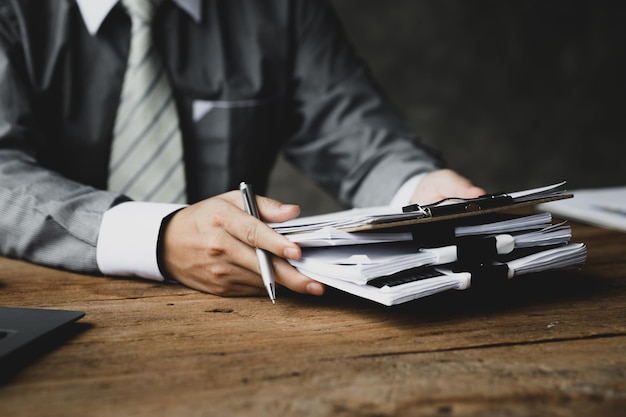 Businessman holding a pile of company financial documents he is\
checking company finances before attending a meeting with the\
finance department concept of corporate financial management